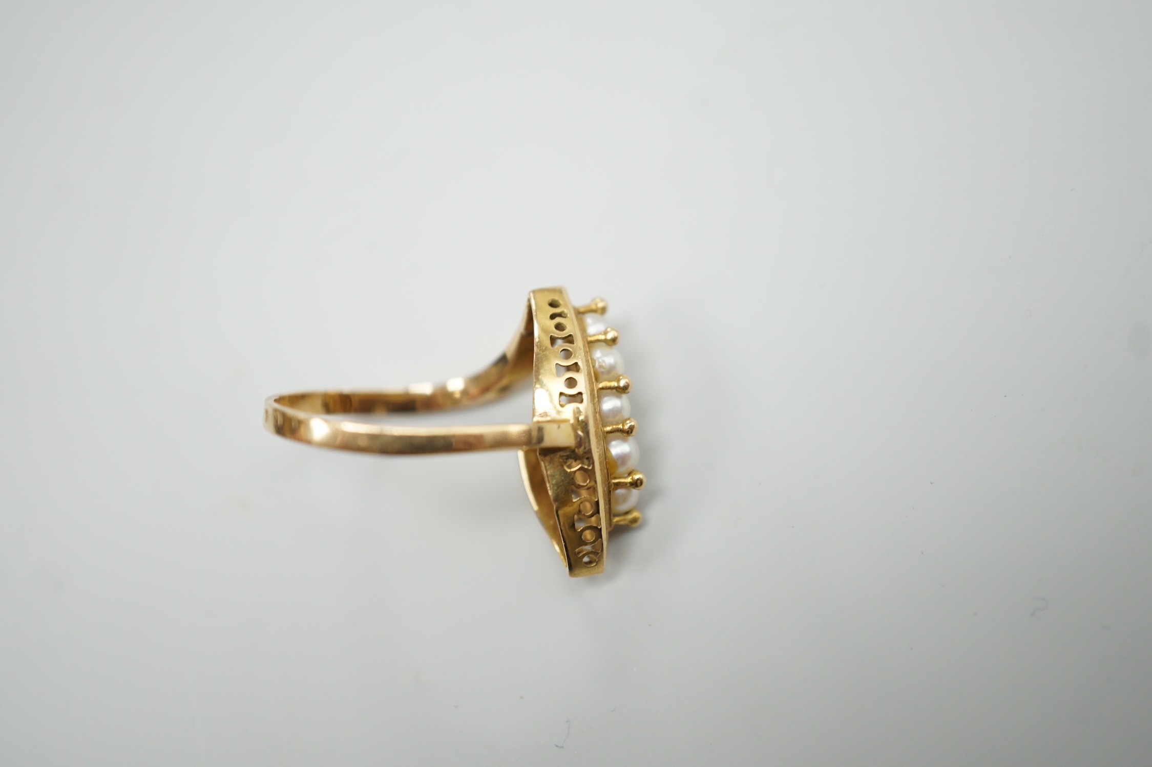 A modern continental yellow metal and seed pearl cluster set marquise shaped ring, size N